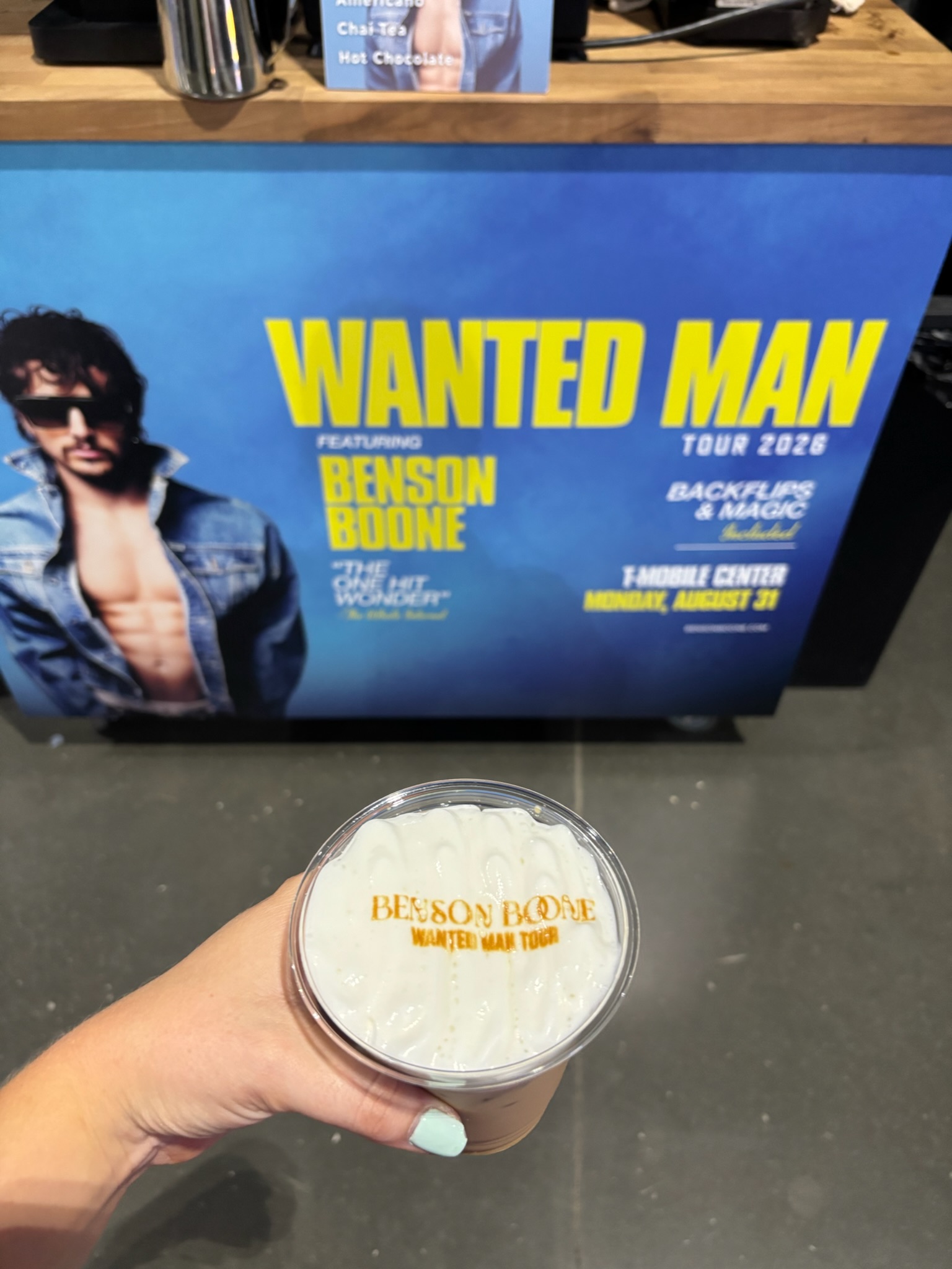 Benson Boone printed latte held in front of the branded concert display at T-Mobile Center in Kansas City