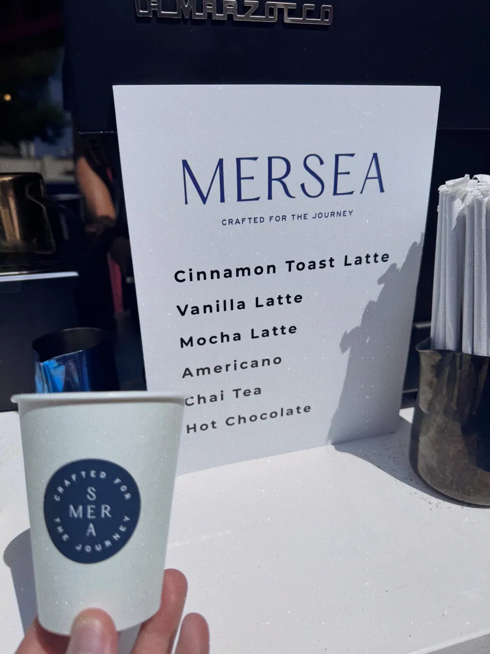 Mersea branded coffee cup beside the custom activation menu