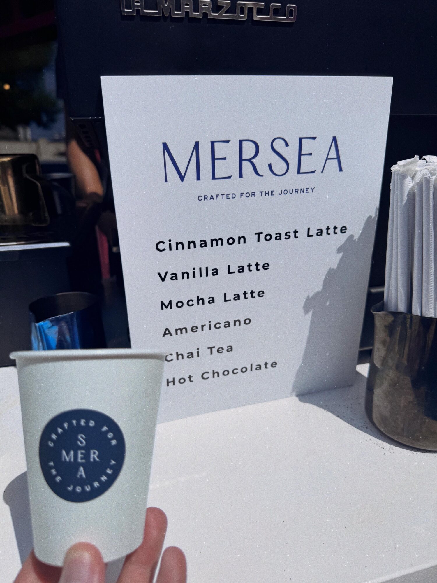 Mersea branded coffee cup beside the custom activation menu